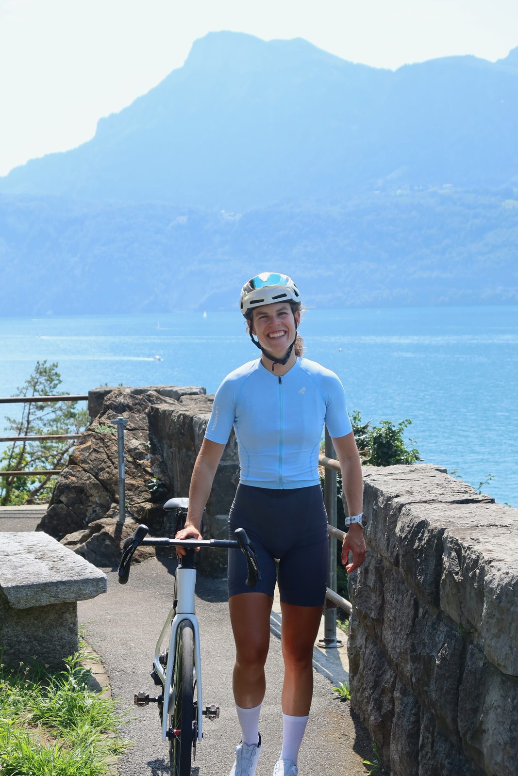 Carmina lachet ufem Veloweg am See, hinter ihre d'Bärge.